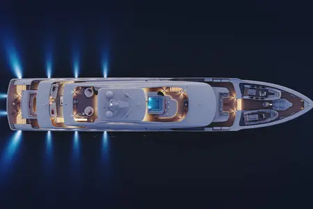 Project Frida - Aerial view of a well-lit yacht at night on dark waters, featuring multiple deck