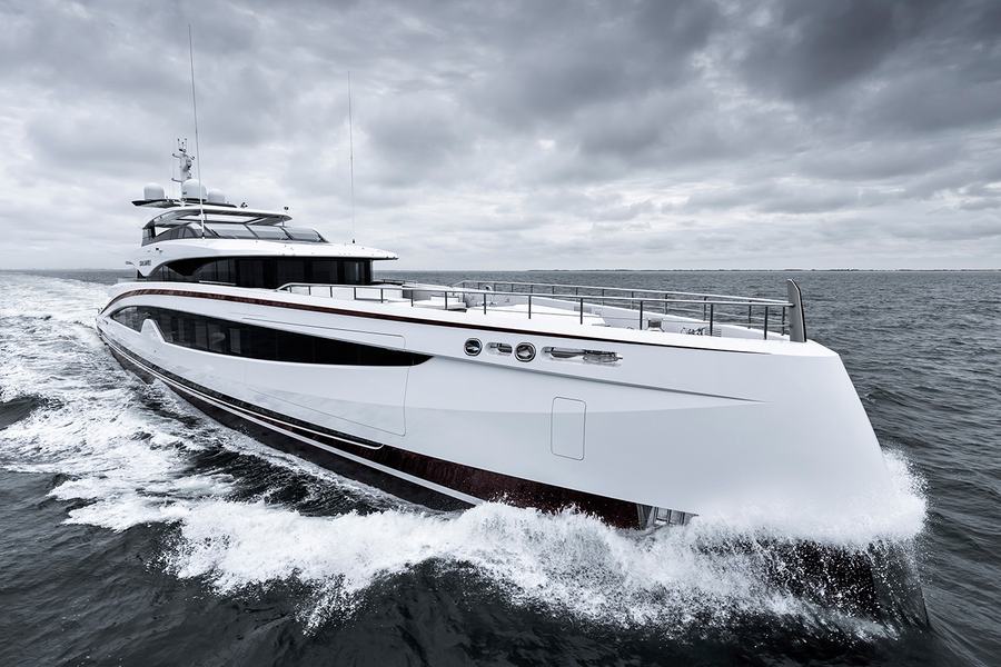 Sparta - A sleek white luxury yacht cruising through the water with a cloudy sky overhead